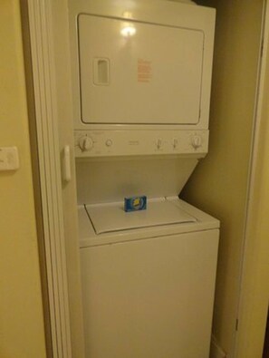 A compact, white, wall-mounted washer and dryer unit with a control panel and a detergent box on the top. - Disney Dreams Penthouse Water View Mall Restaurant (Orlando)