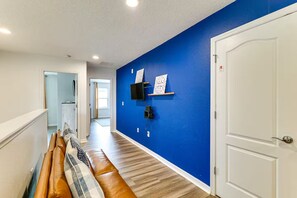 Ein Flur mit blauer Wand, einer weißen Tür und einer Bank mit Kissen.