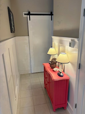 A bathroom with a white bathtub, a red vanity with two lamps, and a towel rack above the tub. - Where Isle Be•Relax & Unwind• 4 bed• 4 bath• Sleeps 8 (Emerald Isle)