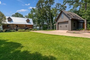 Eine zweistöckige Blockhütte mit Metalldach und Garage.