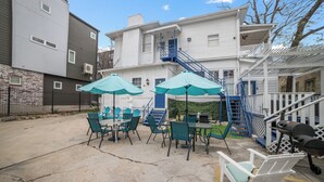 A patio with outdoor seating, a barbecue grill, and a staircase leading to a balcony. - Downtown Mansion 10 bedrooms/7.5 baths, 34+ people, 11car gated parking, Jacuzzi (San Antonio)