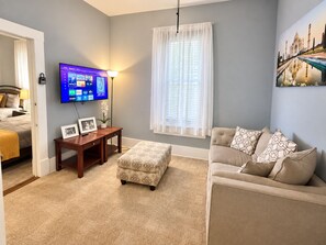 A hotel room with a bed, a TV, a sofa, and a painting of the Taj Mahal. - Downtown Mansion 10 bedrooms/7.5 baths, 34+ people, 11car gated parking, Jacuzzi (San Antonio)