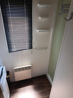 A narrow hallway with a window with blinds, a white radiator, and a door with a coat hook. - Mobile home 50 meters from the beach Natural surroundings Family vacations (Agde)