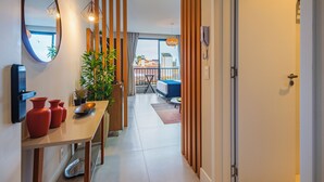 A modern hotel room with a dining area, a view of the outside, and a balcony. - Studio Saint Garden - Sunset - Swimming pool with ocean view - Gastronomy (Florianópolis)