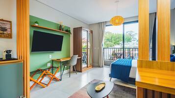 Une chambre d’hôtel moderne dotée d’un grand lit, d’un bureau avec une chaise, d’un balcon avec vue et d’un téléviseur fixé au mur.