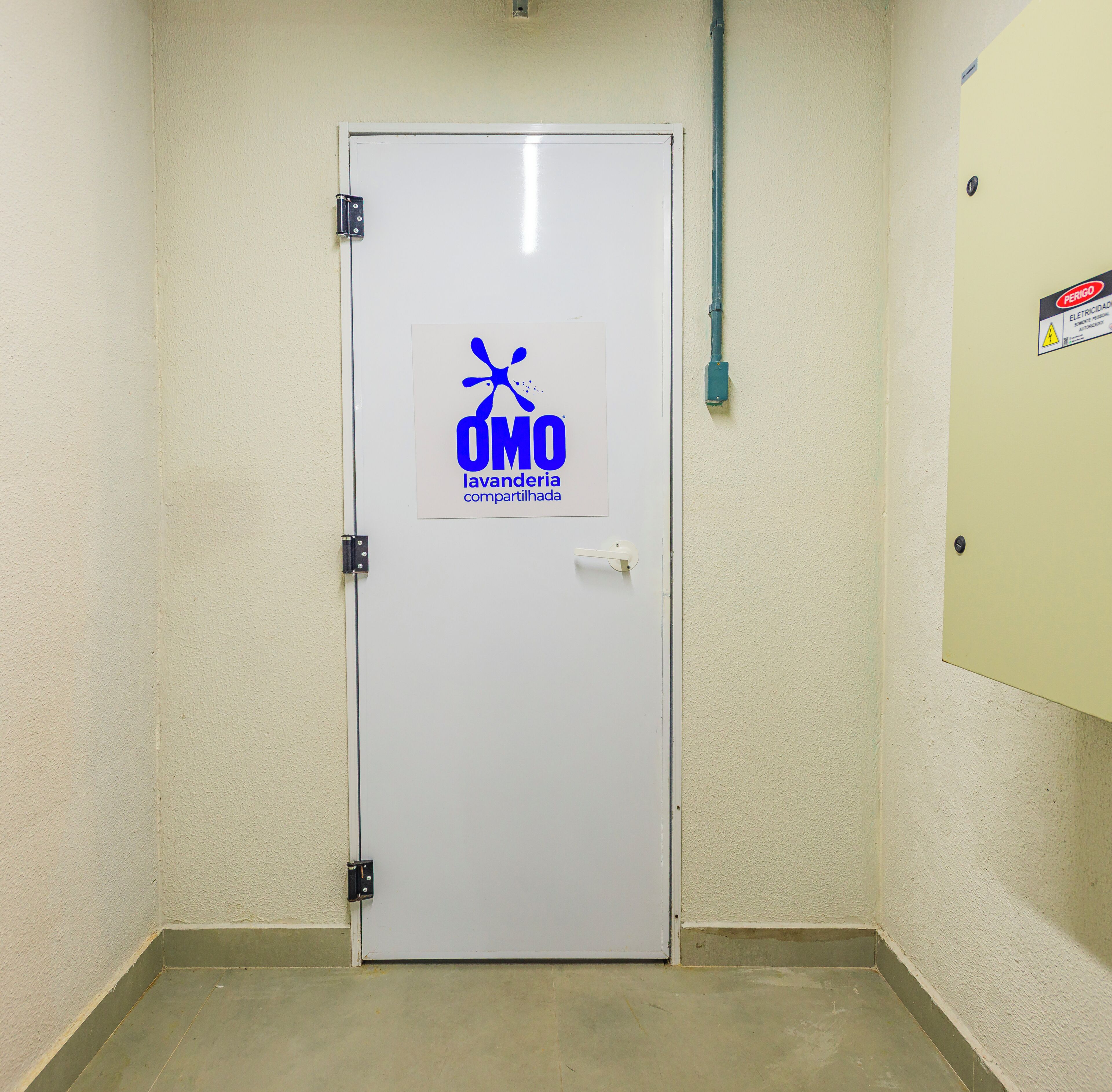 Uma porta branca com logotipo e texto indicando uma lavanderia compartilhada.