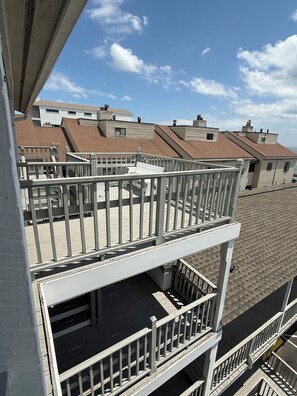 Ein mehrstöckiges Gebäude mit Balkonen, bewölkter Himmel und angrenzenden Häusern.