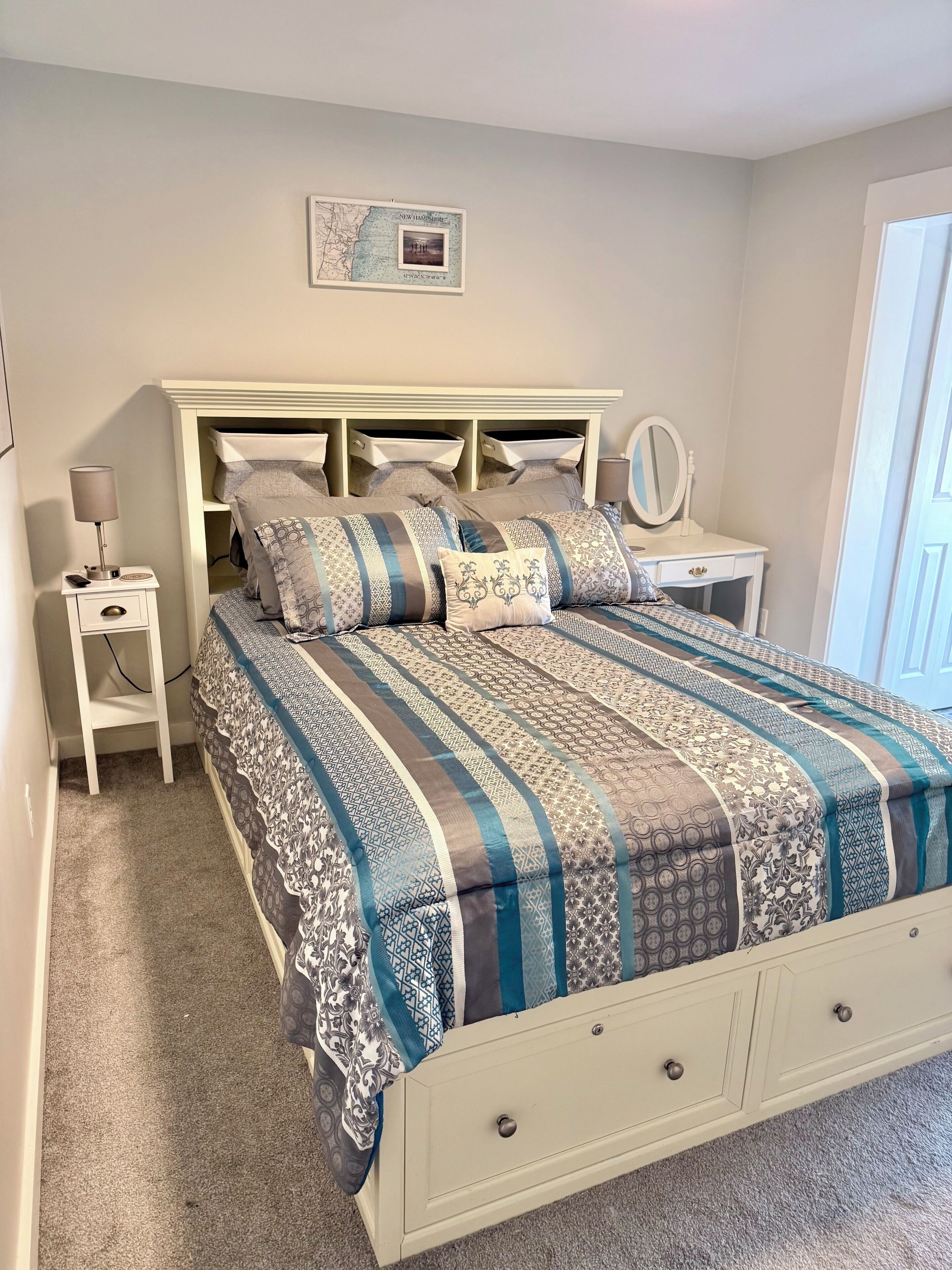 A bedroom with a bed, nightstands, a dresser, a mirror, and a framed map on the wall.