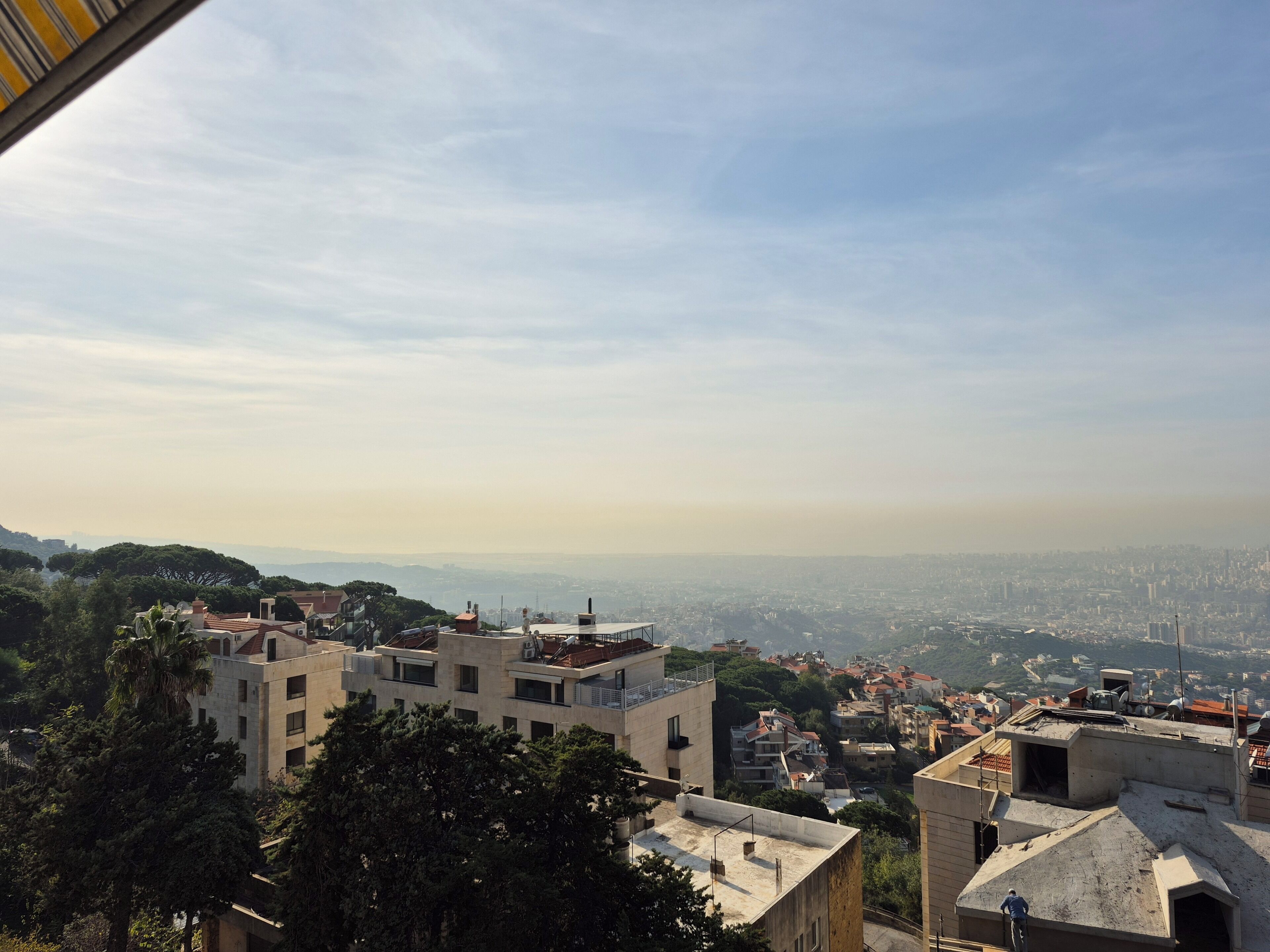 Panoramica urbana con edifici, alberi e cielo sereno.