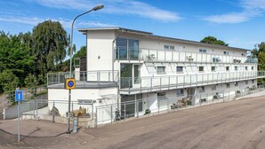 Un edificio de varios pisos con techo plano, ventanas grandes y un balcón.