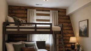 Une chambre avec un lit superposé, un mur en bois, une table de chevet avec une lampe et un tableau encadré accroché au mur.