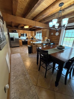 A wooden interior with a kitchen, dining area, and a large window.