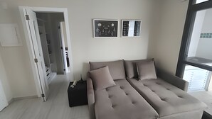 Una sala de estar moderna con un sofá, una mesita y dos cuadros en la pared.
