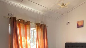 Une chambre à coucher avec un lit, un canapé, un tapis bleu et des rideaux.