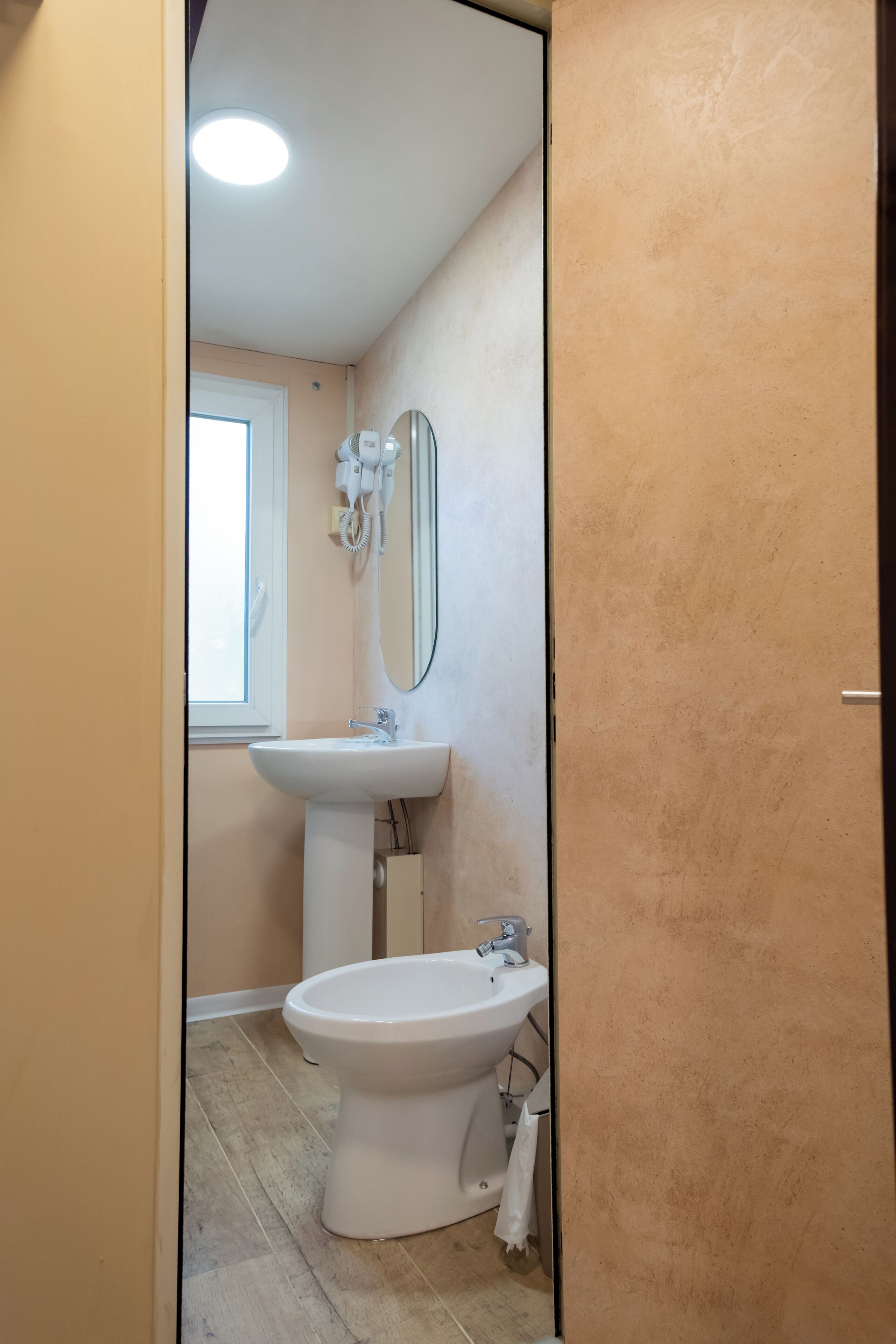 A bathroom with a white sink, a mirror, and a toilet.