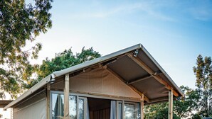 A small, single-story cabin with a wooden deck and a covered porch. - real village roma (Roma)