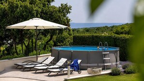 A swimming pool with lounge chairs and an umbrella, surrounded by greenery and a clear view of the landscape. - Gorgeous home in Selca with WiFi (Selca)