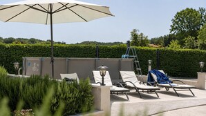 An outdoor seating area with lounge chairs, a large umbrella, and a wall-mounted heater. - Gorgeous home in Selca with WiFi (Selca)
