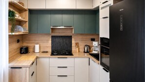 A modern kitchen with a black refrigerator, a stove, and a coffee maker. - Gorgeous home in Selca with WiFi (Selca)