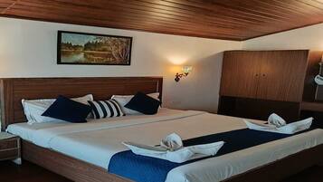 Un letto matrimoniale con testiera in legno, un comodino, un armadio e un punto luce a parete.