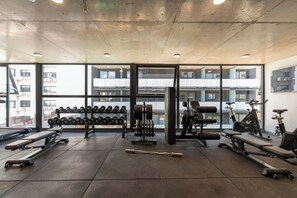 A gym with weightlifting equipment, treadmills, and stationary bikes. - Modern WTC Studio Apartment | Gym + Pool (Montevideo)