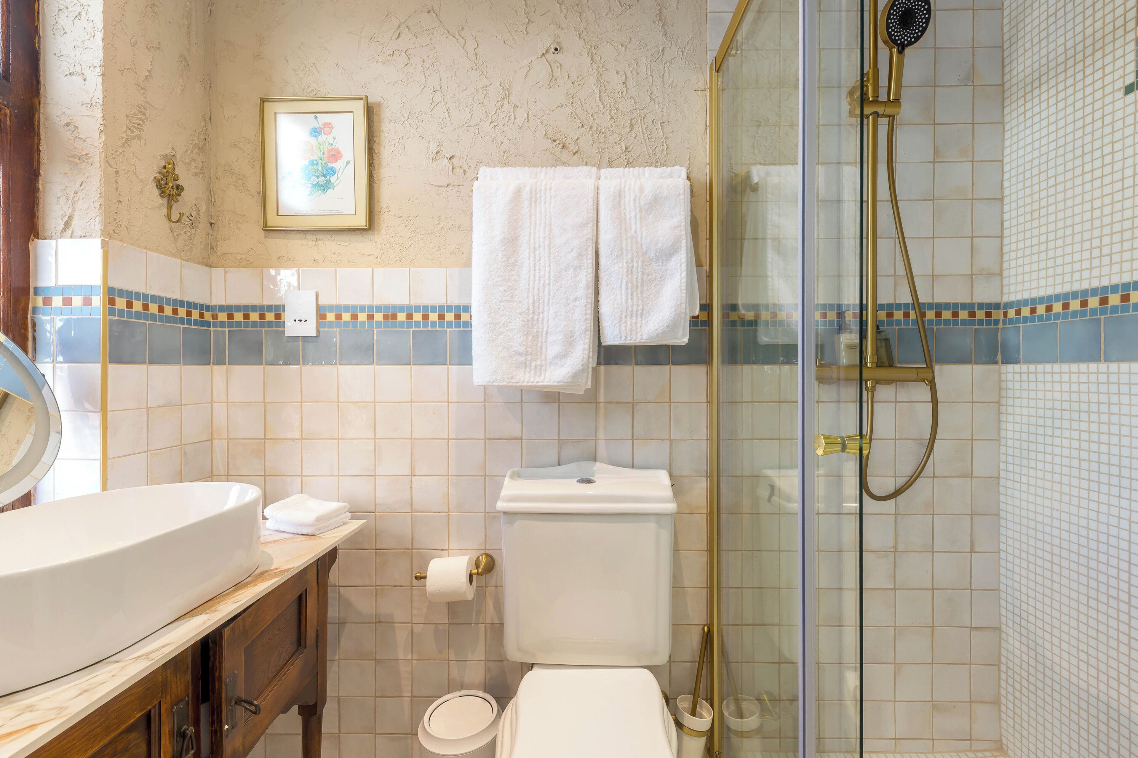 A bathroom with a toilet, sink, and shower.