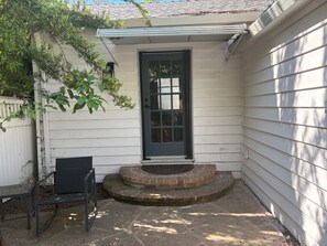 A house with a front door, a small porch, and a bench. - Walkable 2-bedroom Land Park Cottage (Sacramento)