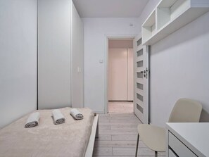 Une chambre à coucher avec un lit, une chaise, un bureau et une armoire.