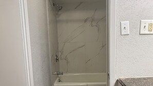 Un bany amb dutxa, banyera i vàter.