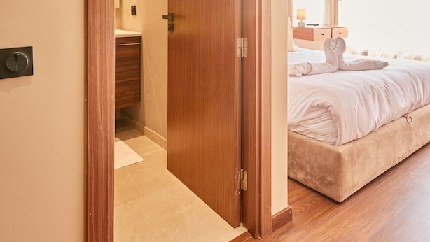 Un dormitorio con puerta de madera, una cama y una mesita de noche.
