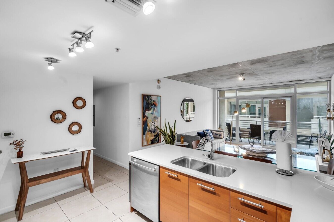 A modern kitchen with a central island, a built-in dishwasher, and wooden cabinets.