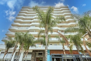A multi-story hotel with a modern design, featuring balconies on each floor and a prominent entrance with signage. - Luxury 3BR | Prime Casablanca | Designer Stay (Casablanca)