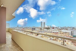 Un balcó amb vista a la ciutat, incloent-hi edificis alts i un cel clar.