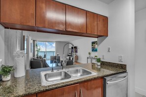 Eine moderne Küche mit Granit Arbeitsplatten, Edelstahlgeräten und Holzschränken.
