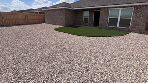 A residential building with a gravel driveway, a fenced backyard, and a clear sky. - Colgate Cottage - 3BR/2BA - Family Friendly (Lubbock)