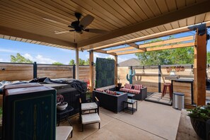 An outdoor patio with a ceiling fan, wooden pergola, and a barbecue area. - The Quincy - 4BR/2BA - Southwest Lubbock (Lubbock)