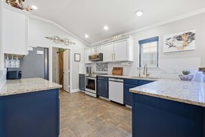 A kitchen with white cabinets, a microwave, an oven, and a dishwasher. - The Quincy - 4BR/2BA - Southwest Lubbock (Lubbock)