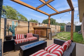 An outdoor patio with wicker furniture, a drinks station, and a barbecue area. - The Quincy - 4BR/2BA - Southwest Lubbock (Lubbock)