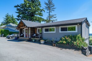 Une maison à deux étages avec un porche à l’avant, un garage et une allée.