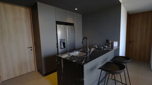 Eine moderne Küche mit einem Einbaukühlschrank, einer Spüle und einem Gasherd.