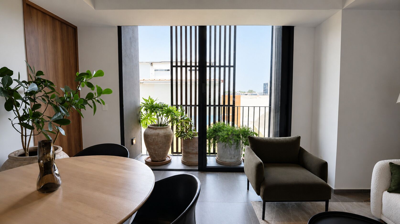 Un salon moderne comprenant une table à manger, des chaises, un canapé et des plantes en pot.