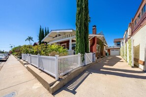 A residential street with houses, a white fence, and a clear blue sky. - Mission Hills retreat, walkable, free parking (San Diego)