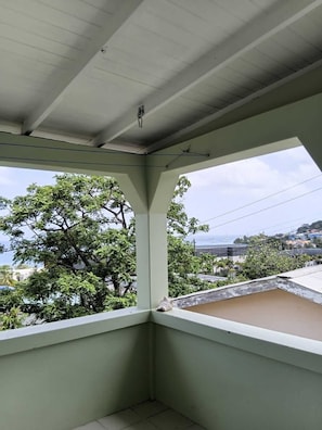A balcony with a view of trees and buildings. - A stylish 3-bdrm coastal-inspired retreat overlooking Grand Anse Beach. (Saint George)