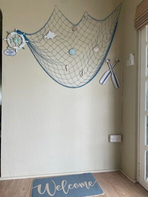 Ein Zimmer mit Fußmatte, einer Wandnetz mit Dekorationen und zwei Schlägern.