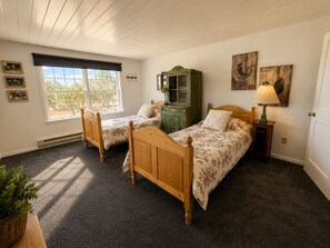 A bedroom with two wooden beds, a green dresser, and a window with blinds. - 200 Acre Retreat, Family Friendly, Stargazing, More (Hesperus)