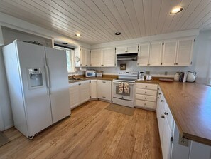 A kitchen with white cabinetry, a refrigerator, a microwave, an oven, and a wooden countertop. - 200 Acre Retreat, Family Friendly, Stargazing, More (Hesperus)