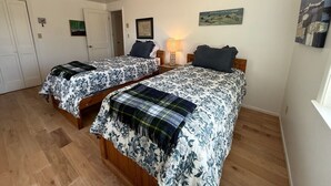 A bedroom with two beds, wooden flooring, a lamp, and artwork on the walls. - 200 Acre Retreat, Family Friendly, Stargazing, More (Hesperus)