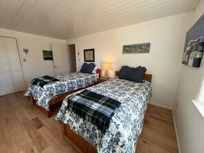 A bedroom with two beds, wooden flooring, a lamp, and artwork on the walls. - 200 Acre Retreat, Family Friendly, Stargazing, More (Hesperus)