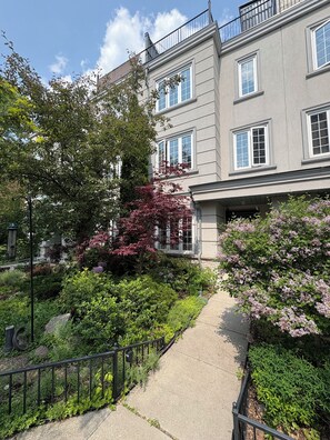 A multi-story residential building with a paved pathway leading to the entrance. - Toronto East Convenient Professionally Decorated Urban Oasis (Toronto)