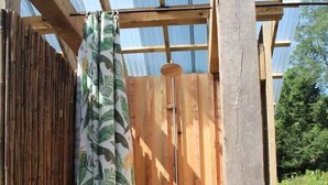 Eine Holzkonstruktion mit Bambuszaun, Holztür und einem gemusterten Vorhang.